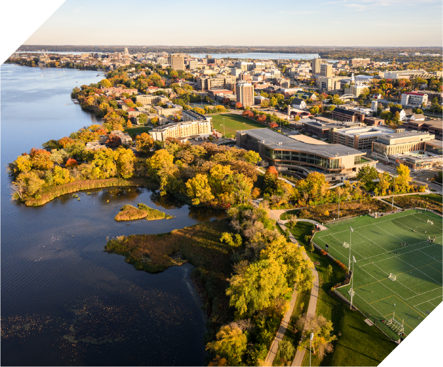 aerial view of a lakeshore with trees and buildings