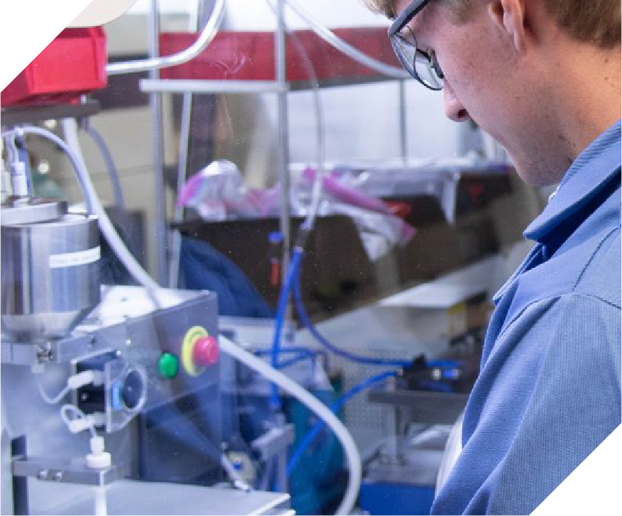 white man with safety glasses working on scientific equipment